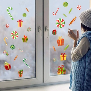 Cozy holiday scene showing festive candy cane and gift box window stickers on glass