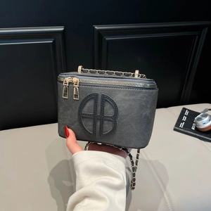 Grey square box bag with gold metal chain strap and large letter logo detail