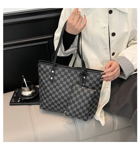 Detail view of large tote bag with black and grey checkerboard pattern and small pouch