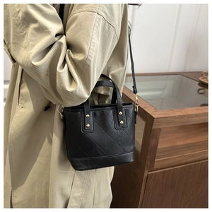 Vue détaillée du sac cabas matelassé noir avec rivets dorés et doubles poignées