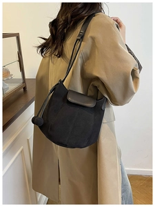 Détail du sac seau noir mat avec pompon sphérique et bandoulière réglable