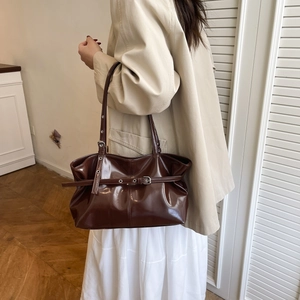 Glossy dark brown shoulder bag with silver buckle details and retro vintage style