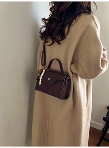 Détail du sac bandoulière en daim marron foncé avec perles vintage et fermoir aimanté