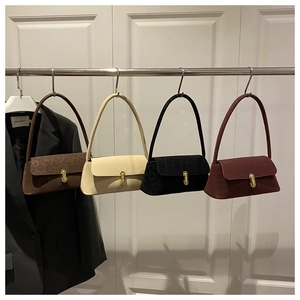 Detail of vintage suede shoulder bags featuring signature gold U-shaped metal buckles