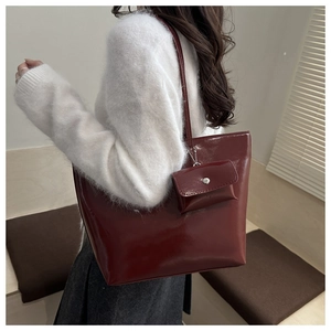 Detail of dark red tote bag in glossy leather with matching detachable mini coin purse