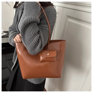 Caramel brown tote bag detail with matching detachable mini pouch and silver hardware