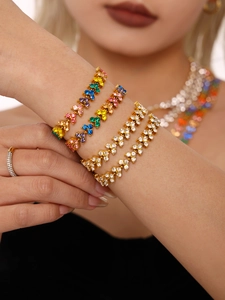 Close-up of sparkling colorful zircon bracelet set and gold plated necklaces on wrist