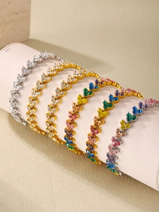 Close-up of luxury triangle zircon bracelets in gold and silver finish with colorful gems