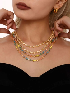 Close-up of luxury 18k gold layered necklace with colorful sparkling zircon stones