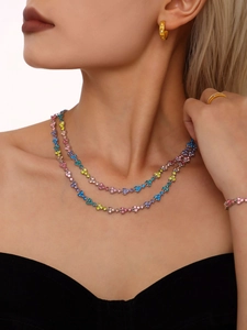 Model wearing a luxury layered floral necklace with colorful zircons and 18k gold plating