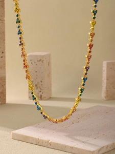 Detailed close-up of 18k gold plated necklace with rainbow zircon floral motifs on stone