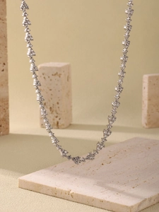 Detailed close-up of a luxury silver-tone necklace with pavé-set zircons on stone decor