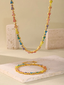 Detail of 18k gold plated necklace with colorful zircons on luxury stone textures