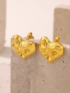 Détail de boucles d'oreilles cœur en or 18K avec texture de lave sur surface en pierre