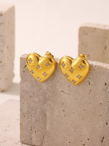 Détail de boucles d'oreilles cœur plaqué or 18K avec zircons sertis en étoile sur pierre