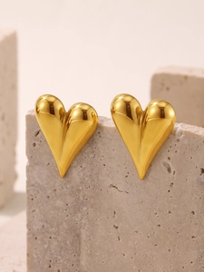 Vue détaillée de boucles d'oreilles cœur doré 3D sur pierre avec finition miroir moderne