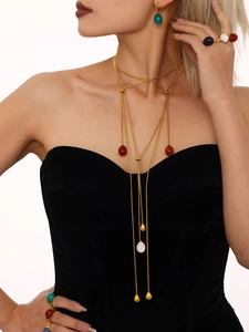 Detailed view of layered 18K gold-plated snake chains with colorful resin pendants