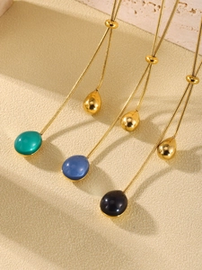 Detailed view of adjustable gold snake chains with green, blue, and black resin pendants