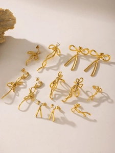 Detailed view of 18K gold plated bow earrings with tassels and zircon stones