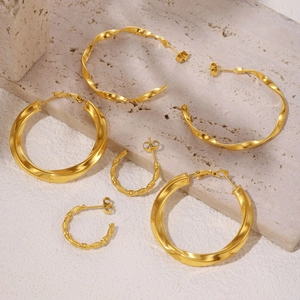 Three pairs of 18K gold plated stainless steel twisted C-shaped hoop earrings on stone