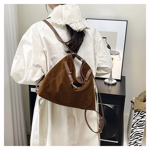 Mannequin portant un grand sac cabas en daim marron sur un trench-coat élégant