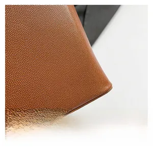 Close-up of premium brown lychee grain leather texture and fine stitching on bucket bag