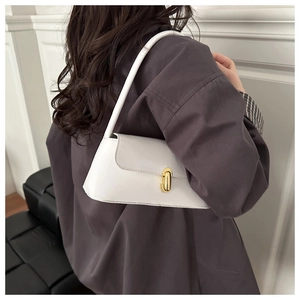 Detailed back view of model wearing white leather baguette bag with gold metal buckle
