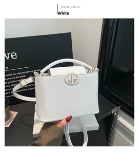 Detail of white pebble grain leather bucket bag with gold circular metal buckle