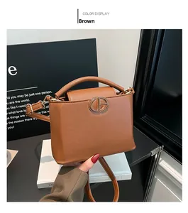Detail of tan pebble leather bucket bag featuring gold interlocking CP logo and handle