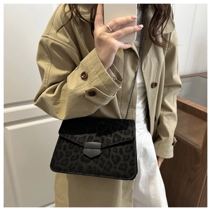 Détail du sac léopard avec chaîne dorée et fermoir métallique sur un trench-coat élégant