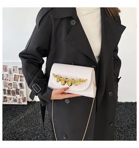 Sac bandoulière blanc rectangulaire avec fermoir ondulé doré et fine bandoulière chaîne
