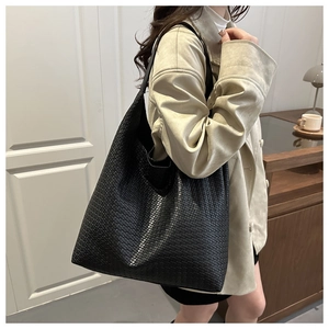 Detail shot of the black woven texture and large capacity of this hobo tote bag