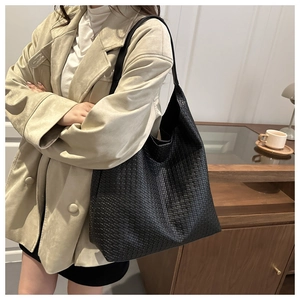 Detail of black woven leather hobo bag showing the intricate textured pattern