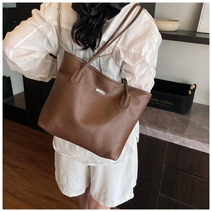 Sac cabas en cuir marron avec plaque logo métallique et texture grainée élégante