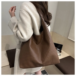 Deep brown woven leather tote bag shown on a model for casual commuting style