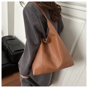 Detail view of a brown woven tote bag showing its premium texture and large capacity size