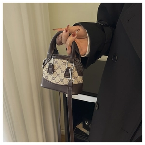 Détail du mini sac coquille avec motif monogramme marron et bandoulière en cuir