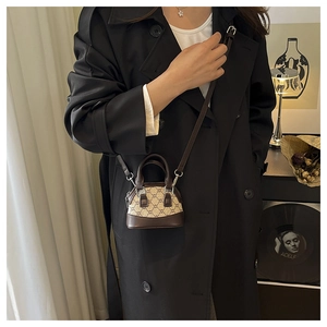 Détail d'un sac bandoulière vintage en toile monogramme marron et finitions en cuir