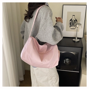 Detail of pink waterproof nylon gym bag with long shoulder strap and large capacity