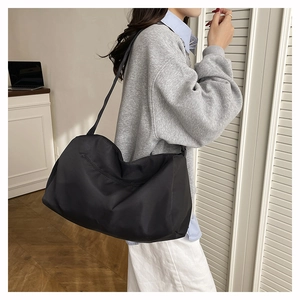 Close-up of lightweight black waterproof nylon travel bag with wide crossbody strap