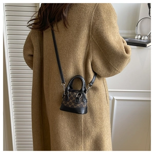 Detailed back view of a mini shell crossbody bag in vintage monogram pattern on a wool coat