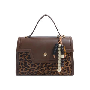 Brown leopard print handbag with a wide top handle and decorative wooden beads