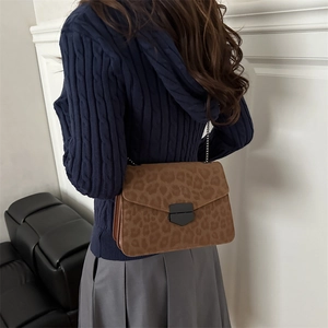 Sac bandoulière léopard marron avec bandoulière chaîne et boucle métal sur mannequin