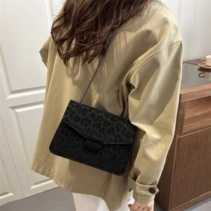 Sac bandoulière à imprimé léopard avec chaîne dorée porté sur une veste beige large