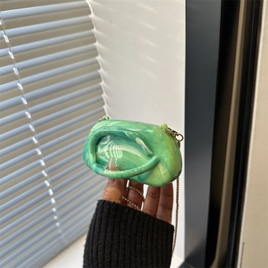 Green marble acrylic mini crossbody bag with gold chain strap shown held by hand