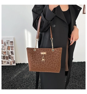 Detail of leopard print tote bag with golden deer charm and chain leather strap