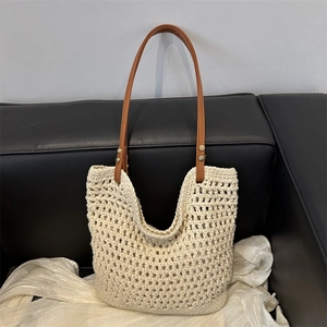 Woven cotton shoulder bag with hollow mesh design and brown leather straps for autumn 2024