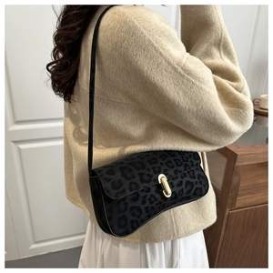 Leopard print suede shoulder bag with gold metal buckle lock shown on model