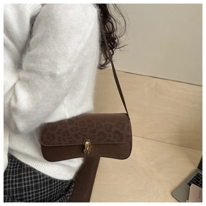 Detail of leopard print suede shoulder bag with golden twist lock and vintage buckle