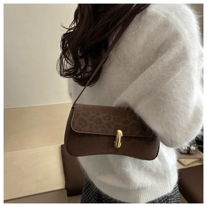 Close-up of brown leopard print underarm bag with elegant gold metal buckle detail